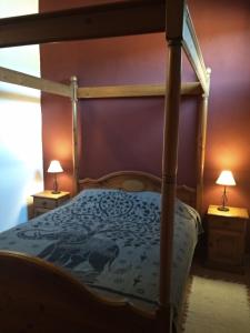 a bedroom with a canopy bed with two night stands at La Tierra Verde Casita in Alcuéscar