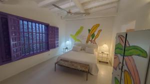 a bedroom with a bed and a bench in it at Hotel Boutique Casa Rosalía in Valledupar