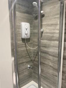 y baño con ducha y puerta de cristal. en Ali's holiday apartments F2, en Blackpool