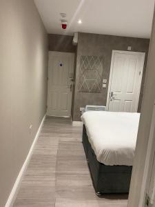 1 dormitorio con 1 cama y pasillo con puerta en Ali's holiday apartments F2 en Blackpool