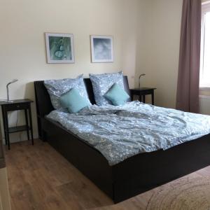 a bed with blue pillows in a bedroom at Friesenauster - große Ferienwohnung für bis zu 6 Personen in Jever