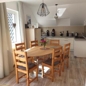 a kitchen and dining room with a wooden table and chairs at Friesenauster - große Ferienwohnung für bis zu 6 Personen in Jever