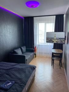 a bedroom with a bed and a couch and a tv at Ehostel360 in Ivano-Frankivsk