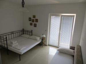 a white bedroom with a bed and a window at Apartments Lucija in Brela