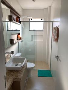 a bathroom with a sink and a toilet and a shower at Lindo Apartamento no Mariscal, Bombinhas, com estacionamento e quintal, a 290 metros da praia do Canto Grande!!! in Bombinhas