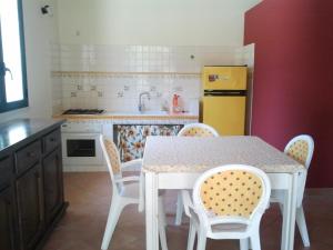 a kitchen with a table and chairs and a yellow refrigerator at Casa Vacanze Al Ma Gi in Castellammare del Golfo