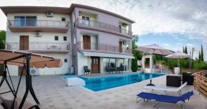 a villa with a swimming pool in front of a building at Petronas Villa in Kariá