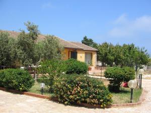 a house with a garden with flowers in front of it at Casa Vacanze Al Ma Gi in Castellammare del Golfo