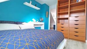 a blue bedroom with a bed and a blue wall at LE REFLET MERVILLE - Central & chic - AufildeLorient in Lorient