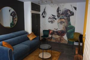 - un salon avec un canapé et un tableau mural dans l'établissement Duplex charmant idéalement situé, à Dole