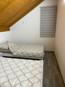 two beds in a room with wooden ceilings at Villa Alfareed فيلا الفريد سراييفو in Sarajevo