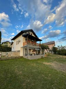 a house with a balcony in a yard at Villa Alfareed فيلا الفريد سراييفو in Sarajevo