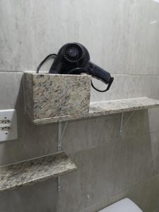 un bagno con telefono appoggiato su un muro di Condomínio Vitória a Vila Velha