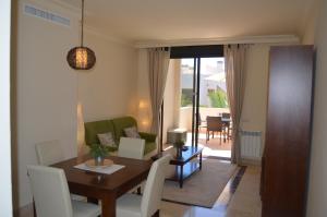 uma sala de estar com uma mesa de jantar com cadeiras brancas em Roda Golf Resort 5508 - Resort Choice em Roda