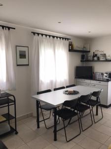 een keuken met een witte tafel en stoelen in een kamer bij Appartamento da 2 locali a Bosco Gurin in Bosco Gurin