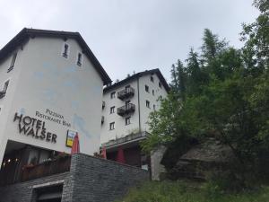 a hotel building with a hotel maker sign on it at Appartamento da 2 locali a Bosco Gurin in Bosco Gurin