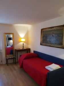 a bedroom with a red bed and a mirror at Ca Palazzo in Venice