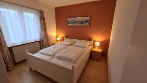 sypialnia z łóżkiem z 2 lampami i oknem w obiekcie Appartement Alpenperle w mieście Unterbäch