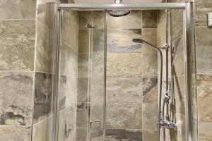 a shower with a glass door in a bathroom at Lavender Apartment - Spacious apartment close to the beach in Deal