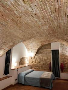 uma cama num quarto com uma parede de tijolos em Casa Cavaliere em Perugia