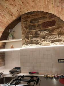 a kitchen with a sink and a stone wall at Casa Cavaliere in Perugia