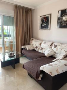 Una sala de estar con un sofá y una mesa de cristal. en Residencial Duquesa, en San Luis de Sabinillas 32 fotos más