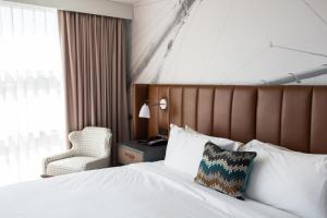 a hotel room with a bed and a chair at Hotel Indigo Old Town Alexandria by IHG in Alexandria +26 photos