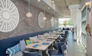 a dining room with white tables and blue chairs at Hotel Indigo Old Town Alexandria by IHG in Alexandria