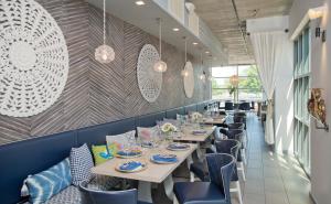 a dining room with white tables and blue chairs at Hotel Indigo Old Town Alexandria, an IHG Hotel in Alexandria