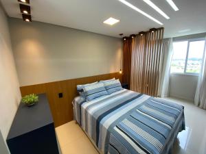 um quarto com uma cama com lençóis azuis e brancos em Itaparica LUXO & DESIGN 24 HORAS em Vila Velha