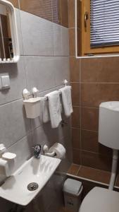 a bathroom with a sink and a toilet and towels at Apartment and rooms"Tabašnice"Tuzla centar in Tuzla