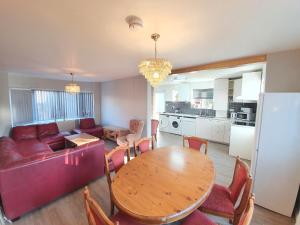 a living room with a table and a red couch at St Georges house, Premium 3 bed Home Slough, Legoland, Windsor in Slough