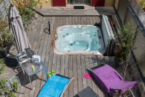 - un bain à remous sur une terrasse avec une table et des chaises dans l'établissement Domaine et chambres d'Hôtes des Fées, à Pretin