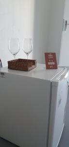 2 verres à vin assis au-dessus d'un réfrigérateur dans l'établissement Pousada Alto da Serra, à Serra de São Bento