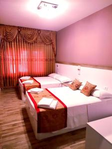 three beds in a room with purple walls at Hotel Venice Tour in Mestre