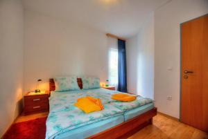 1 dormitorio con 1 cama con 2 almohadas de color naranja en Apartments Peran, en Šibenik