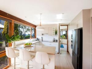 a kitchen with white appliances and a large window at Beach Street Residence Huskisson in Huskisson