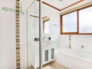 a bathroom with a white tub and a sink at Beach Street Residence Huskisson in Huskisson +15 photos
