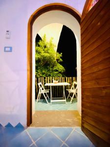 an archway leading to a patio with a table and chairs at Vign'Alva in Castelsardo