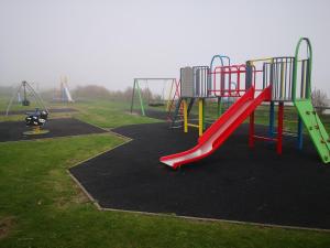 a playground with a slide in a park at Cloughey Beach House in Kircubbin