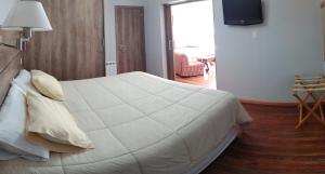 Un dormitorio con una gran cama blanca en una habitación. en Casa Laura Dto 2, en San Carlos de Bariloche