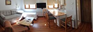 een woonkamer met een bank en een tafel en een keuken bij Casa Laura Dto 2 in Bariloche