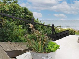 une plante en pot assise sur un banc près de l'eau dans l'établissement 4 person holiday home in Mesinge, à Mesinge