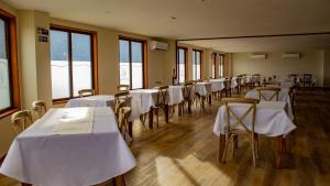 a row of tables and chairs with white table cloths at Gran Hotel Aysen in Puerto Aisén