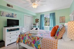 a bedroom with a bed and a flat screen tv at Villa with Prime Location Walk to Beach and Coligny! in Hilton Head Island