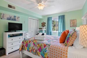 Un dormitorio con una cama y un televisor de pantalla plana. en Walk to Coligny Beach Park Family-Friendly Villa, en Hilton Head Island