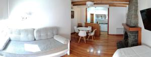 Casa Laura Bariloche في سان كارلوس دي باريلوتشي: غرفة معيشة مع أريكة وطاولة في غرفة