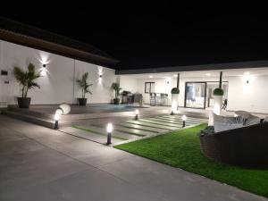 a patio with lights and a pool at night at ViLLA DREAMS JF in Arona