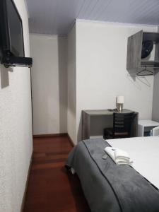 ApiaíにあるHotel Apiaiのベッド1台とテレビが備わる小さな客室です。