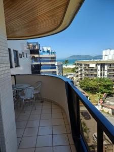 - Balcón con mesa y sillas en un edificio en Cobertura Cabo Frio 4 quartos , 50 metros da praia en Cabo Frío